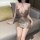 Woman wearing a shimmering gold liaru factory sexy lingerie dress, featuring a deep v-neck and cut-out details.