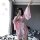A woman poses with a phone, wearing a pink floral japanese-style kimono robe set. the ensemble features lace details and a bo...
