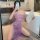 A woman poses in a luxurious bathroom, wearing a sheer purple lace dress with floral patterns. the elegant design features of...