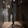 Woman in black backless lace long dress holding wine glass, elegant lingerie for women.