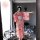 A woman poses in a mirror wearing a pink floral japanese kimono-style lingerie set, featuring long sleeves and cat ears, perf...