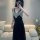 A woman models a black lace gold velvet embroidered long sleep dress featuring a backless design and tie belt, perfect for wo...