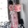 A woman stands against a wall wearing a pink floral japanese kimono-style cat-themed sleepwear set, featuring long sheer fabr...