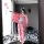 A person wearing a pink floral japanese-style kimono with cat ears takes a photo in front of a mirror, surrounded by floating...
