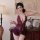 A woman poses elegantly in a luxurious setting, wearing a deep purple lace lingerie set. the dress features sheer cutouts and...