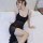 A woman wearing a sheer black lace mesh sleep dress with adjustable straps, sitting elegantly on a bed. the dress features a ...