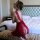 A woman poses elegantly in a luxurious setting, wearing a red lace sleep dress with a split-back design. the sheer fabric add...
