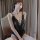 A woman poses elegantly in a black lace sleepwear set, featuring sheer fabric and intricate detailing. the uniform-inspired d...