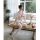A woman poses elegantly on a wooden table wearing a sheer white long night set, featuring a matching sleep dress with delicat...