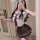 A woman poses in a mirror wearing a schoolgirl outfit, featuring a white blouse with a tie and a plaid skirt, perfect for cos...