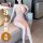 Woman wearing a pink deep v lace chemise with sheer mesh, sitting on a couch. the lingerie features a seductive long slip des...