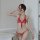 Woman wearing red sheer lace lingerie set with tie straps, featuring babydoll top and matching thong from long night temptati...