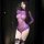 Woman modeling purple sheer mesh bodysuit with long sleeves, lace trim, and black bow garters.
