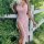 A woman poses outdoors wearing a romantic lace sleep dress featuring a side slit and sheer mesh design, perfect for a sexy ni...