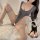Woman wearing sensual ice silk bodysuit with long sleeves, sheer panels, and thigh-high stockings on fluffy white rug.