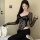 Woman wearing black lace bodysuit with long sleeves and built-in pads, styled in fashion for small bust.