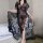 Woman wearing a sexy lace transparent long nightgown set, featuring intricate floral patterns and a seductive design, perfect...