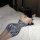 Woman in loveruru sexy leopard print bodysuit bikini, tight-fit nightclub lingerie set, lying on bed.