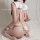 Woman wearing a sexy white maid cosplay dress with lace lingerie, cute apron, and fishnet stockings, posing on a bed.