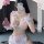 Woman in pink and white maid cosplay dress with lace, sheer mesh, ruffled trim, and bow details.