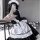 A woman wearing a maid costume cosplay dress, featuring black and white colors with ruffles and a bow, perfect for anime scho...
