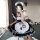 A woman poses in a maid costume cosplay dress, featuring a black and white checkered design with ruffles and paw prints, perf...