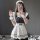 A woman wearing a black and white maid costume, featuring ruffled sleeves, a corseted apron, and a headband, posing with a ph...