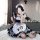 A woman poses in a maid costume cosplay dress, featuring black and white checkered patterns, paws on the apron, and fishnet s...