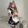 A woman wearing a black and white maid costume cosplay dress, holding a teddy bear, with fishnet stockings and an old-fashion...