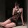 Woman wearing manny night elegant lace halter bodysuit, sheer mesh with floral cutouts, posing in mirror selfie.