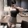 Woman wearing manny night leopard print lingerie set with matching bra and skirt, posing in a modern room.