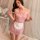 A woman poses wearing a pink maid costume with a strapless design, featuring a bow and apron detail, perfect for role play an...