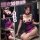 Woman modeling purple and black maid-style lingerie set with fishnet stockings, featuring heart-shaped accents and ruffled de...