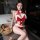 Woman modeling mannyan red velvet christmas bodysuit with white plush trim, halter tie, and open-crotch design for festive sl...