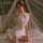 Woman wearing white mannyan french-style lace chemise, sheer sexy sleep dress with delicate embroidery and bodycon fit.