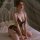 Woman wearing mannyan leopard lace thong bodysuit set, sexy no-remove intimate outfit for small bust, on bed with sheer canop...