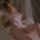 Woman in mannyan sheer lace bodysuit with open-crotch design, underwire push-up sleepwear on bed.