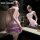 Woman wearing mannyan purple lingerie dress with sheer fabric, cleavage accent, and bodycon fit, posing by mirror.