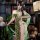 Woman wearing mannyan sheer green lace cheongsam lingerie with side-tie qipao design in vintage library setting.