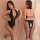 Woman modeling black deep v-neck bodysuit with lace-up back and open-crotch design, paired with fishnet stockings.