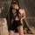 Woman wearing mannyan sexy lace bodysuit dress with sheer mesh cut-outs and halter neckline, posing in elegant bedroom settin...
