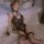 Woman in mannyan sexy lace bunny costume with floral trim, adjustable straps, fishnet stockings, and bunny ears on a ruffled ...