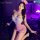 Woman wearing mannyan sexy lace trim mesh bodysuit - sheer sweetheart airline uniform dress in purple-lit room with rose peta...