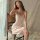 Elegant woman wearing a silky beige dress by mannyan, featuring delicate spaghetti straps and a v-neckline, perfect for luxur...
