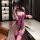 Woman wearing purple mannyan lace bodysuit with underwire and adjustable straps, taking a mirror selfie in a stylish room.