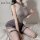 Woman wearing mannyan sexy lingerie set – mesh bodysuit with jk-style skirt and thigh-high stockings, posing on bed.