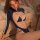 Woman wearing navy blue mannye qing lace cut-out lingerie set with open-crotch design, posing seductively on bed.