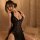 Sexy black lace cheongsam outfit featuring sheer cut-outs and traditional knotted buttons, perfect for elegant evening wear.