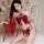 Woman modeling red sheer mesh halter lingerie set with peony embroidery and tassels on bed.