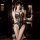 A woman poses elegantly in a black lace lingerie set featuring an open-crotch design, highlighting its intricate patterns and...